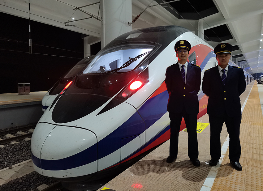 劉銀能（右一）與中國師父鄔俊鴻在動(dòng)車組前合影。受訪者供圖